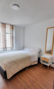 una camera da letto con un letto grande e uno specchio di Otoño Aparta Suite a Ipiales