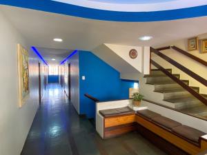 a hallway with blue walls and stairs with a blue ceiling at Elite Palace Hotel in Pará de Minas