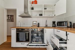 a kitchen with white cabinets and a dishwasher at maremar Apartments - Schlafen in der Altstadt - Luxus Boxspring - Küche in Minden +17 photos