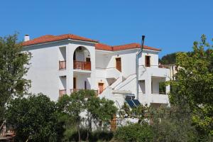 a white building with a red roof at O Ampelonas tou kyr Giorgou in Skopelos Town