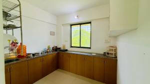 蒂鲁帕蒂Newly Built Beautiful and Spacious 2bhk in Tirupati Near Bus stand and Railway Station的厨房配有木制橱柜和窗户。