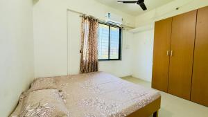 蒂鲁帕蒂Newly Built Beautiful and Spacious 2bhk in Tirupati Near Bus stand and Railway Station的一间有床和窗户的小卧室
