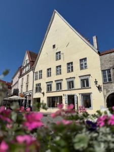 タリンにあるLuxury Suites in the Heart of Medieval Tallinn Old Townのピンクの花が目の前に咲く大きな建物