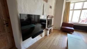 a living room with a large flat screen tv on a wall at Luxury Suites in the Heart of Medieval Tallinn Old Town in Tallinn