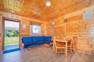 a living room with a blue couch and a table at ZŁOTY OGRÓD in Darłowo