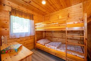 a bedroom with bunk beds in a log cabin at ZŁOTY OGRÓD in Darłowo