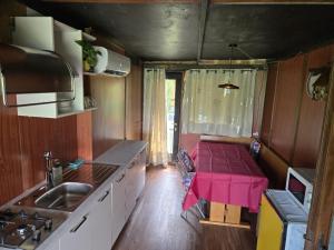 a small kitchen with a pink table in a caravan at castello terrebio in Visnadello