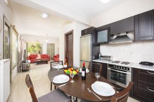 a kitchen with a table and a dining room at Villa Irineos in Karavomylos