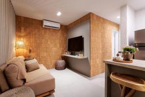 ein Wohnzimmer mit Sofa und Fernseher in der Unterkunft Apartamentos Moana Milagres - Rota Ecológica Milagres in Barra do Camaragibe