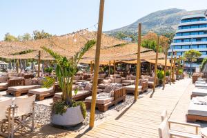 a patio with lounge chairs and umbrellas at a resort at Yacht Hotel in Vlorë