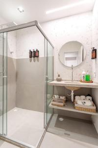 eine Glasdusche in einem Badezimmer mit Spiegel in der Unterkunft Apartamentos Moana Milagres - Rota Ecológica Milagres in Barra do Camaragibe