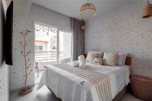 ein Schlafzimmer mit einem Bett mit weißen Laken und einem Fenster in der Unterkunft Apartamentos Moana Milagres - Rota Ecológica Milagres in Barra do Camaragibe + 53 Fotos