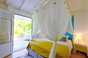 a bedroom with a yellow bed with a canopy at Charming villa with swimming pool for 6-8 in Saint-François +36 photos