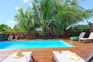 a pool on a wooden deck with two tables and two chairs at Charming villa with swimming pool for 6-8 in Saint-François
