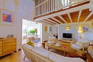 a living room with a couch and a tv at Charming villa with swimming pool for 6-8 in Saint-François