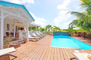 a deck with chairs and a swimming pool at Charming villa with swimming pool for 6-8 in Saint-François