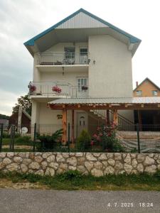 una gran casa blanca con una valla delante en Apartman Lucija, en Žabljak