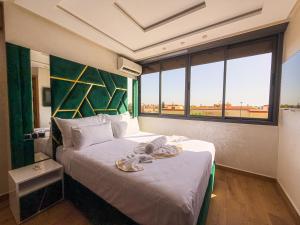 a hotel room with a bed with a large window at Essalmi Luxury Apartment in Marrakech in Marrakech