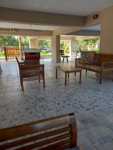a patio with wooden benches and a pool table at olivensun apartment 3 in Gythio