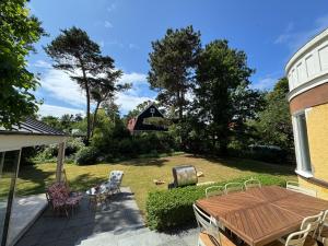 a backyard with a table and chairs and a grill at Spacious Falsterbo Villa - Garden, BBQ, Bikes in Skanör med Falsterbo