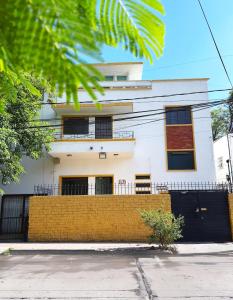 a white building with a yellow wall at Habitación privada La Americana Chapultepec in Guadalajara
