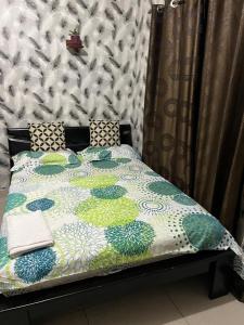 a bed with a quilt on top of it at Residence Madison in Abidjan