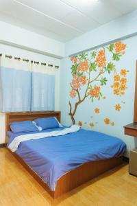 1 dormitorio con 1 cama con un mural en la pared en Chiangmai Tree Hostel, en Chiang Mai