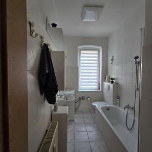a white bathroom with a tub and a sink at Central Apartment in Gera +34 photos