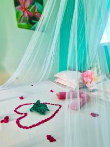 a heart made out of roses on a bed at Frangipani House Nungwi Zanzibar in Nungwi