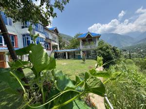 a house on a hill with mountains in the background at ROYALE PEAKS Sonamarg rd in Sonāmarg