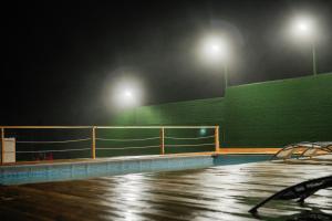 an empty tennis court at night with two lights at My House Resort in Dsegh