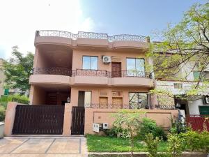 a large pink house with a balcony on top at Modern 3-Bed Retreat E11 PEACEFUL in Islamabad