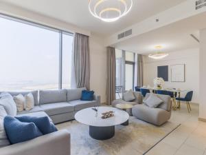 un soggiorno con un divano e un tavolo di TRPS - Creek Rise Tower, Dubai Creek Harbour - 3BR with Marina View a Dubai
