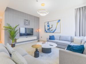 un soggiorno con un divano e un tavolo di TRPS - Creek Rise Tower, Dubai Creek Harbour - 3BR with Marina View a Dubai