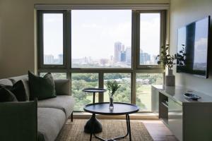 una sala de estar con un sofá y una mesa en Elegant and Modern 2 BR Home Golf Skyline View, en Manila