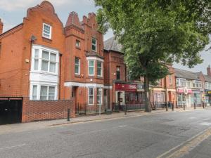 an empty street in front of a brick building at 2 Evington Road in Leicester