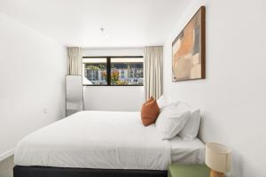 a bedroom with a white bed with a window at Central on Shotover 2 in Queenstown
