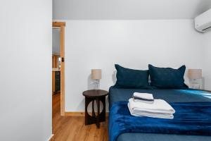 a bedroom with a blue bed and a table at Arbutus Lakeside Stay-Pontoon Rentals-Near TC! in Traverse City +31 photos