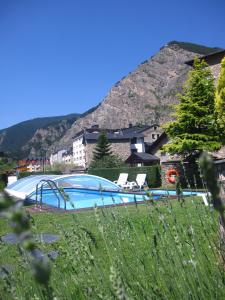 a large swimming pool with a mountain in the background at Hotel Bonavida in Canillo