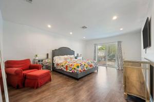 a bedroom with a bed and a red chair at The Hatteras Haven With Pool in Los Angeles +41 photos
