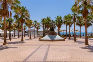 een park met palmbomen en een fontein op het strand bij Light Brisa Apartment in Fuengirola