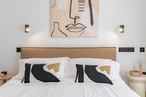 een slaapkamer met een wit bed met zwart-witte kussens bij Light Brisa Apartment in Fuengirola