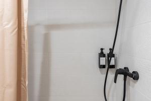 een douche met een zwarte douchekop aan de muur bij Light Brisa Apartment in Fuengirola +14 foto's