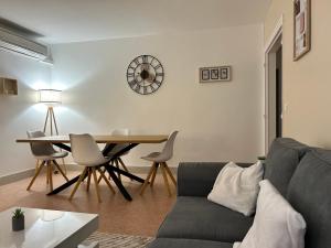 a living room with a couch and a table and a clock at Appartement cocon in La Teste-de-Buch