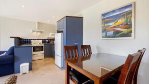 a kitchen and dining room with a table and a blue cabinet at Warm and spacious 2 bedroom, downstairs apartment in Wanaka