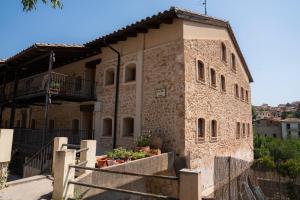 a large stone building with plants in front of it at El Rincon de Beceite in Beceite