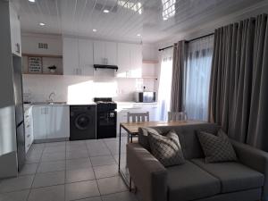 a kitchen and living room with a couch and a table at Garden studio flat in Panorama