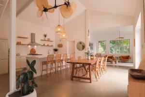 a kitchen and dining room with a table and chairs at Bailan Byron Serene Luxury Villa in Ewingsdale