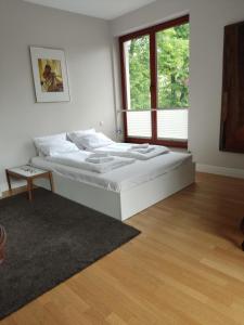 a white bedroom with a bed and a window at Horizon Forest moj-sopot pl in Sopot