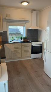 Il comprend une cuisine équipée d'une cuisinière et d'un réfrigérateur blancs. dans l'établissement Hyggehuset, à Bergen